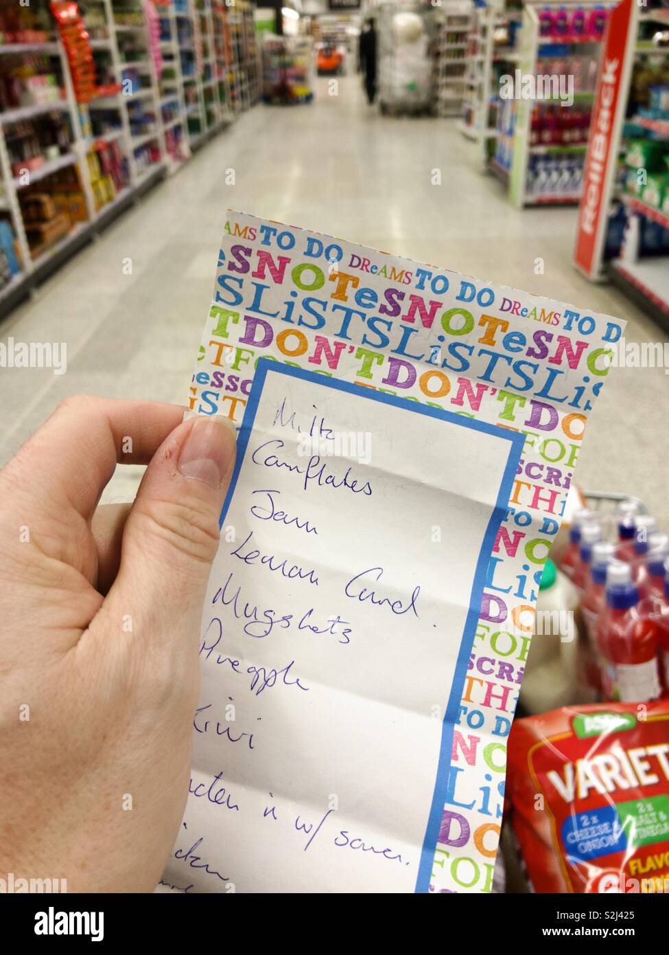 Machen hand mit einem Einkaufszettel in einem Supermarkt. Stockfoto