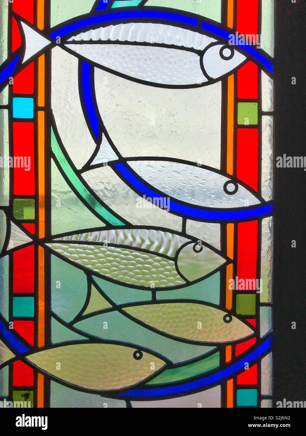 Detail der Fische gestalteten Glasfenster in der Norwegischen Kirche, Cardiff Bay, South Wales. - Smartphone-aufgenommenes Stockfoto