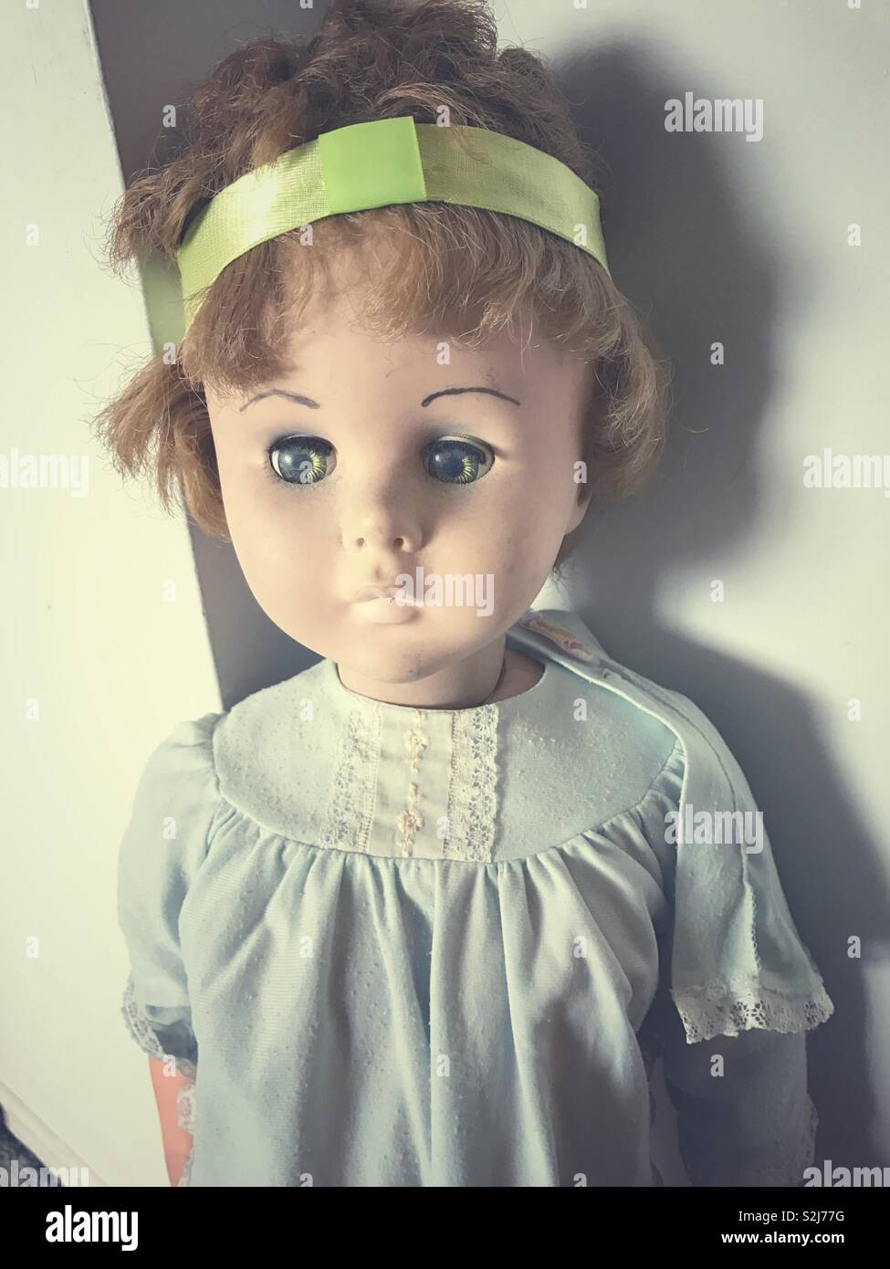 Die vintage Kinder Puppe aus den 60er oder 70er Jahren, getragen aus suchen, mit abgeschnittenen Haare. - Smartphone-aufgenommenes Stockfoto