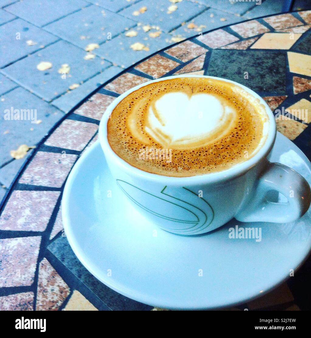 Schönen Cappuccino mit einem Herz in der Schaum erzeugt. Kaffee draußen auf  einem schönen, aber etwas kühl Tag in der Stadt Stockfotografie - Alamy