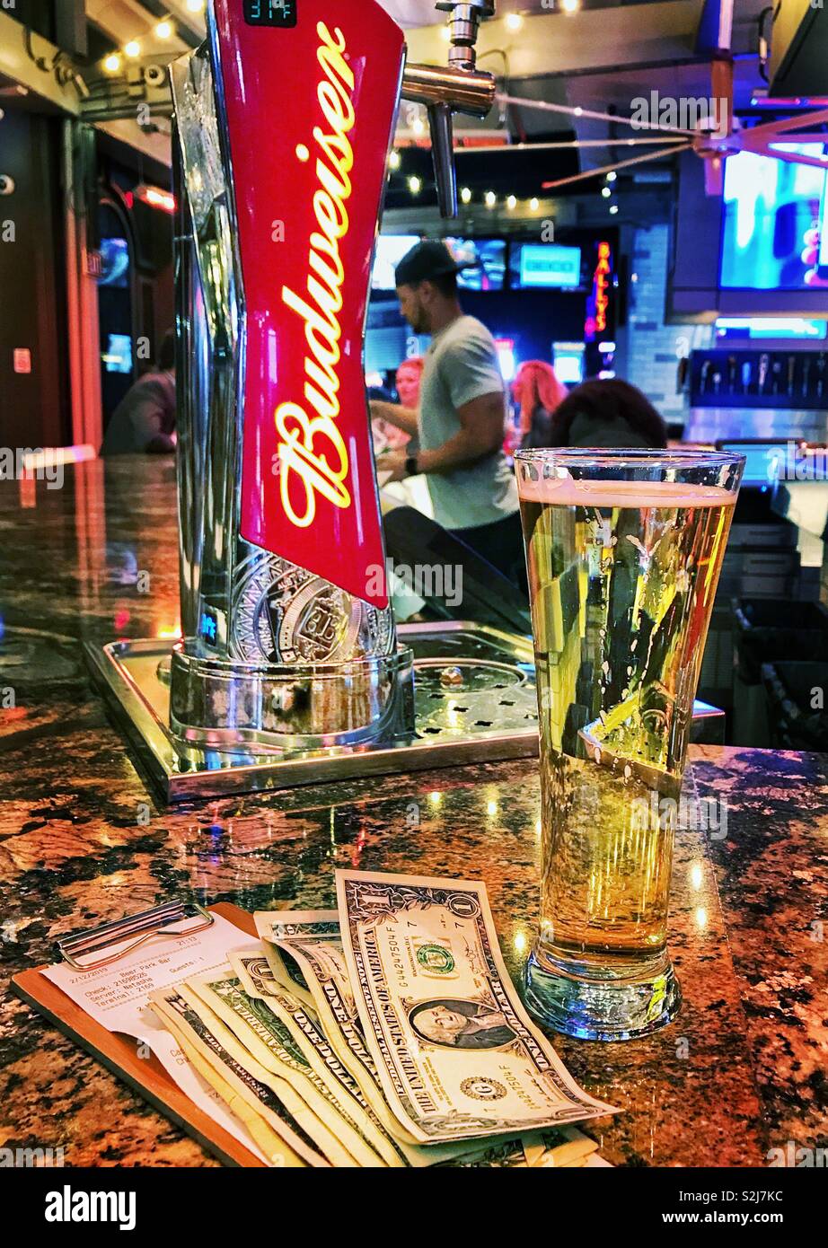 Dollarnoten und eine Knospe an einer Bar in Amerika - Smartphone-aufgenommenes Stockfoto