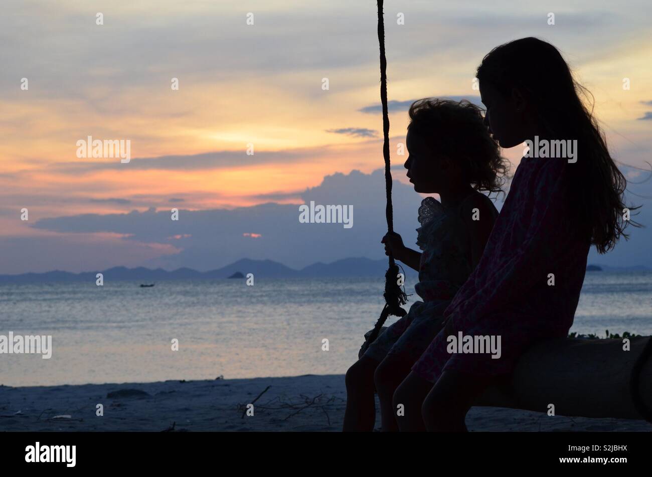 Schwestern bei Sonnenuntergang Silhouetten Stockfoto