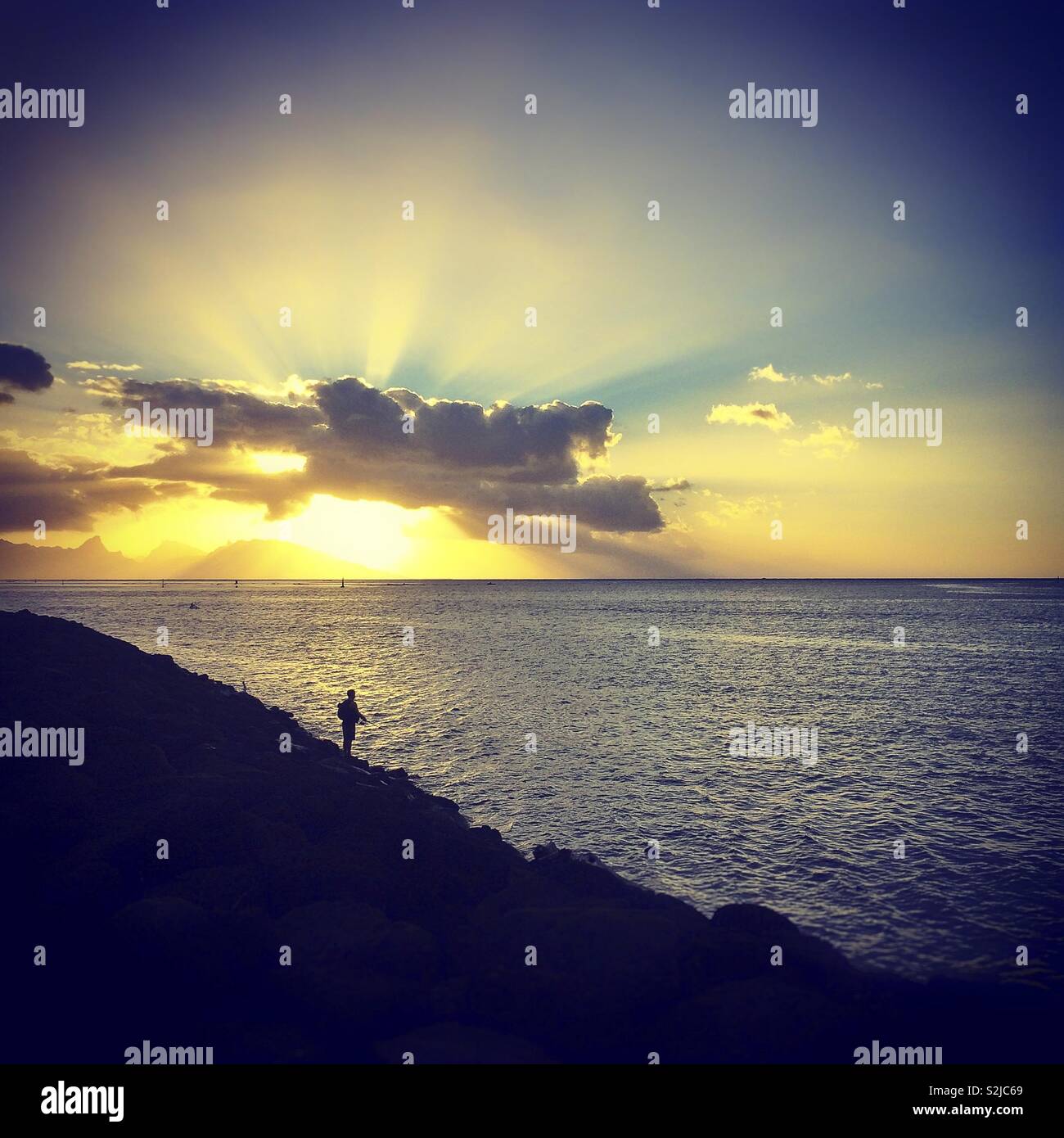 Fischer auf einem Sonnenuntergang über der Insel Moorea Stockfoto