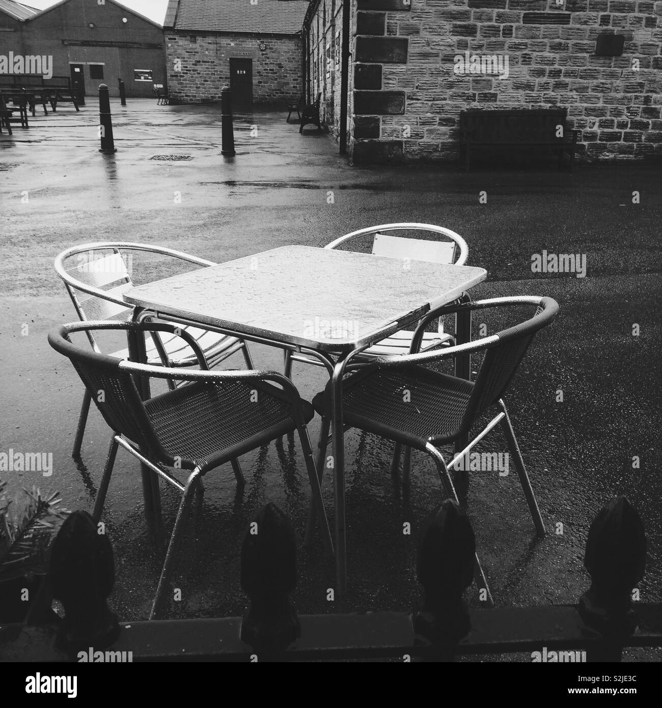 Tisch und Stühle draußen im Regen Stockfoto