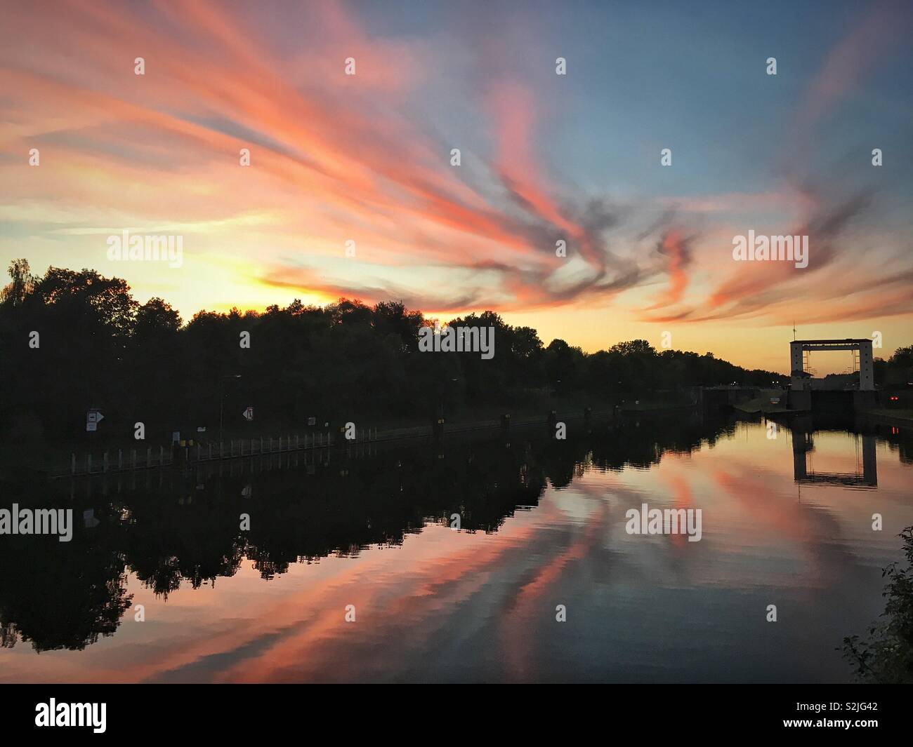 Drone Schuß von Fluss und Watergate Lehnitzschleuse in Oranienburg, Deutschland bei Sonnenuntergang mit perfekten Reflexion Stockfoto