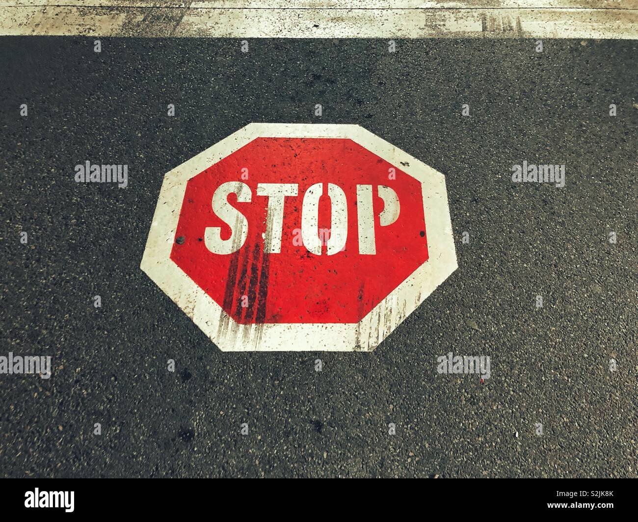 Stop-Schild Straßenmarkierungen mit Bremsspuren in der it Stockfoto