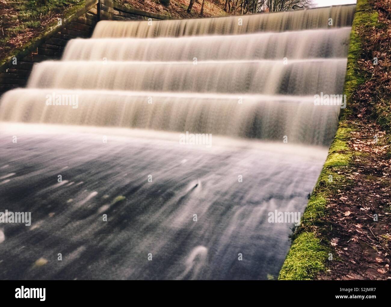 Wasser fließt aus dem Behälter überlaufen. Überlauf von Schafgarbe Reservoir in Rivington, Lancashire - Smartphone-aufgenommenes Stockfoto