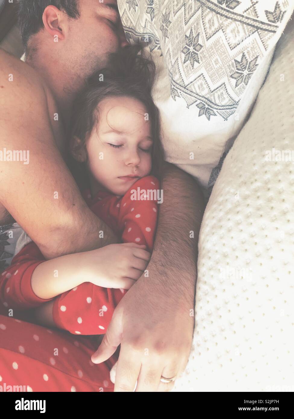 Vater und Tochter schläft und Kuscheln im Bett der Eltern Stockfoto