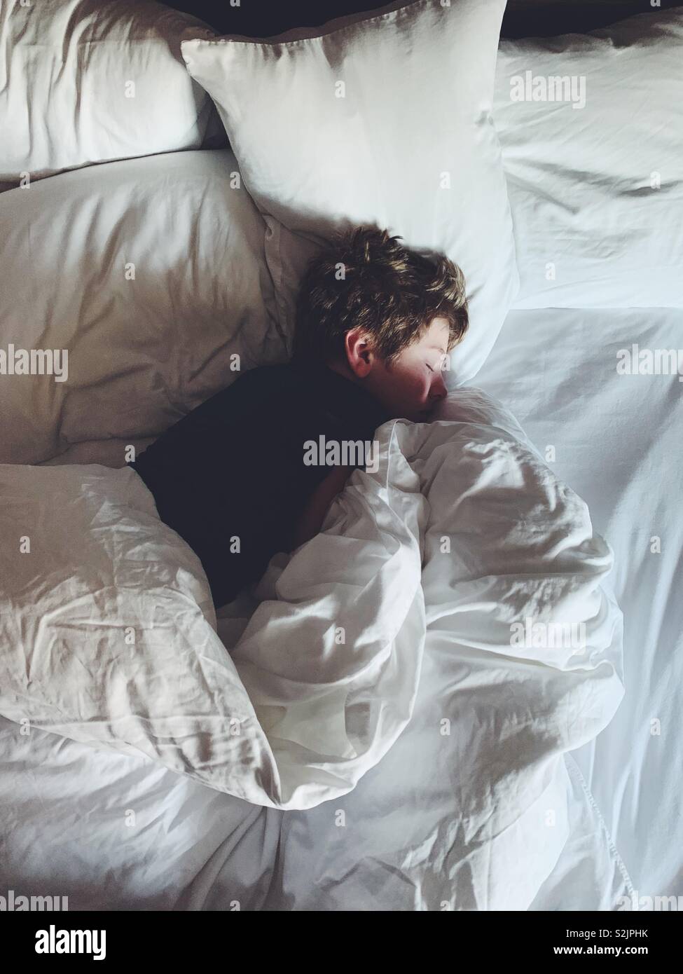 Junge schlafen in einem bequemen Bett Stockfoto