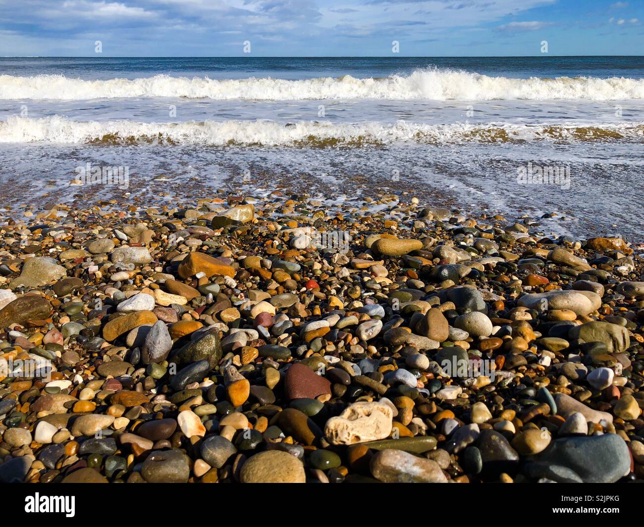 Wellen auf einen Kiesstrand - von einem niedrigen Winkel genommen Stockfoto