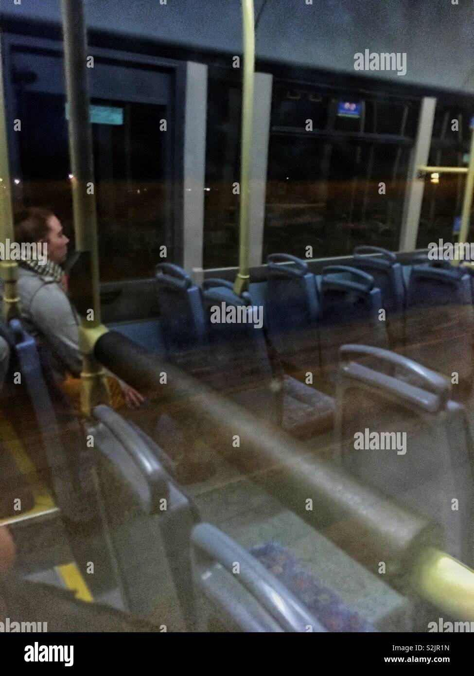 In der Nacht, die Kamera zeigt aus einem Bus-Fenster, die durch Reflexion eine Frau im Bus sitzt. Stockfoto