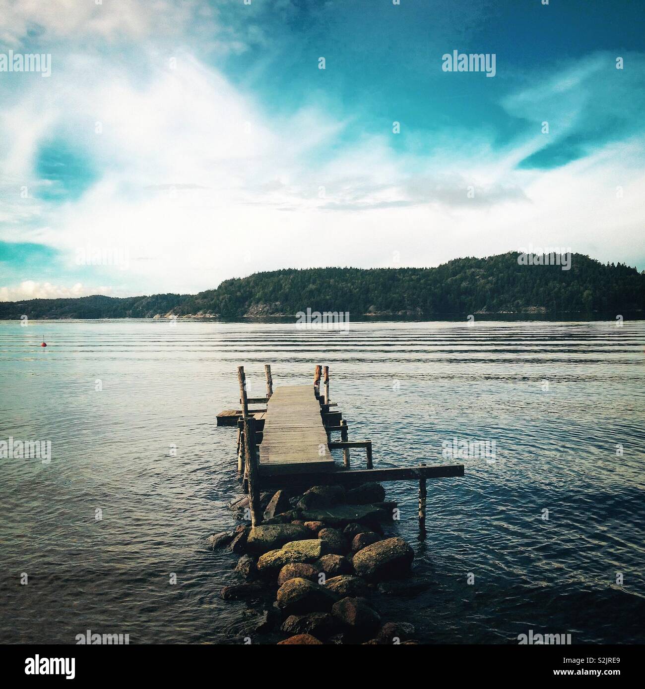 Leicht prekäre Jetty in einem ruhigen See Stockfoto