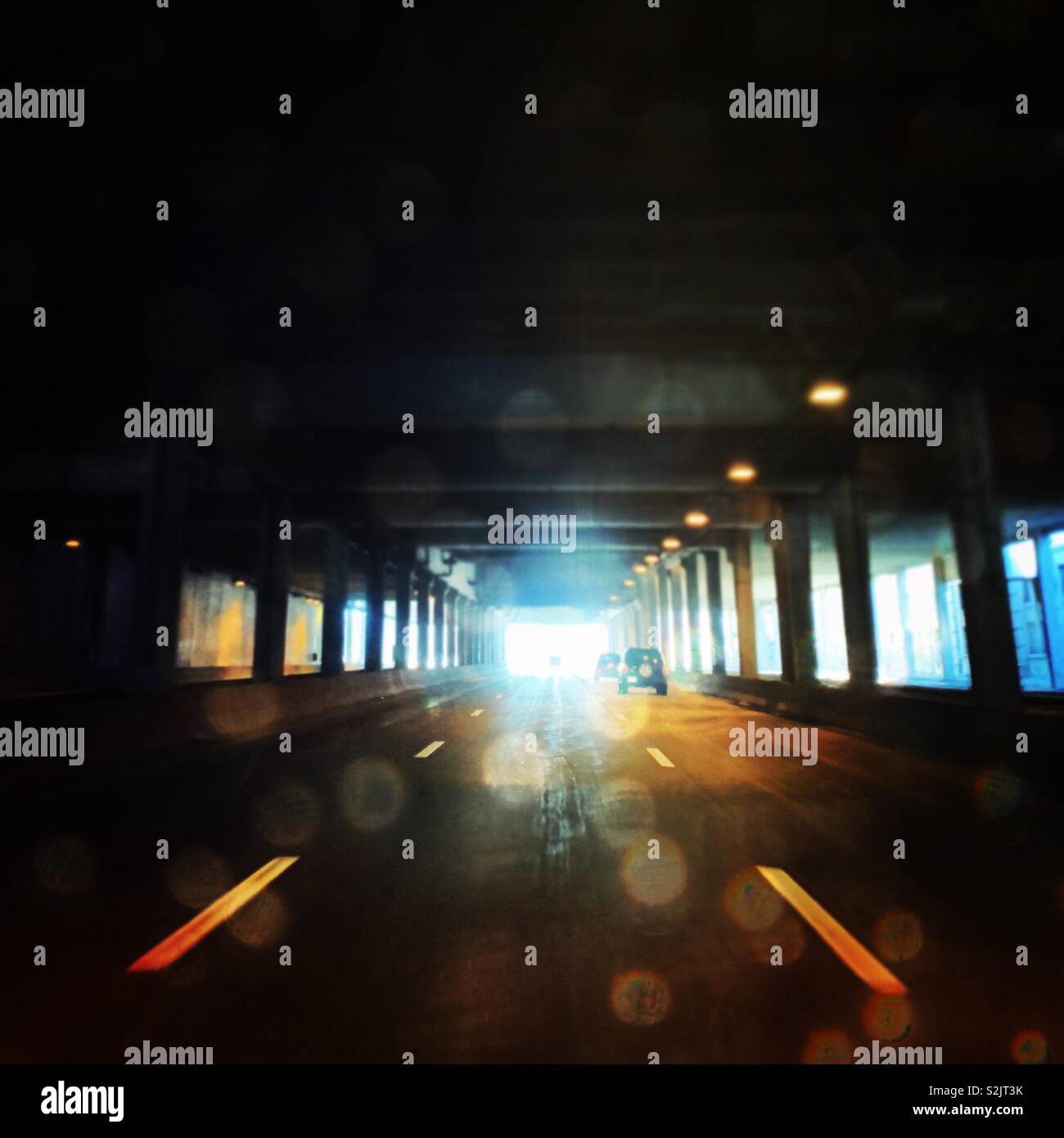 Fahren durch einen Tunnel bei Tag mit Licht am Ende. - Smartphone-aufgenommenes Stockfoto