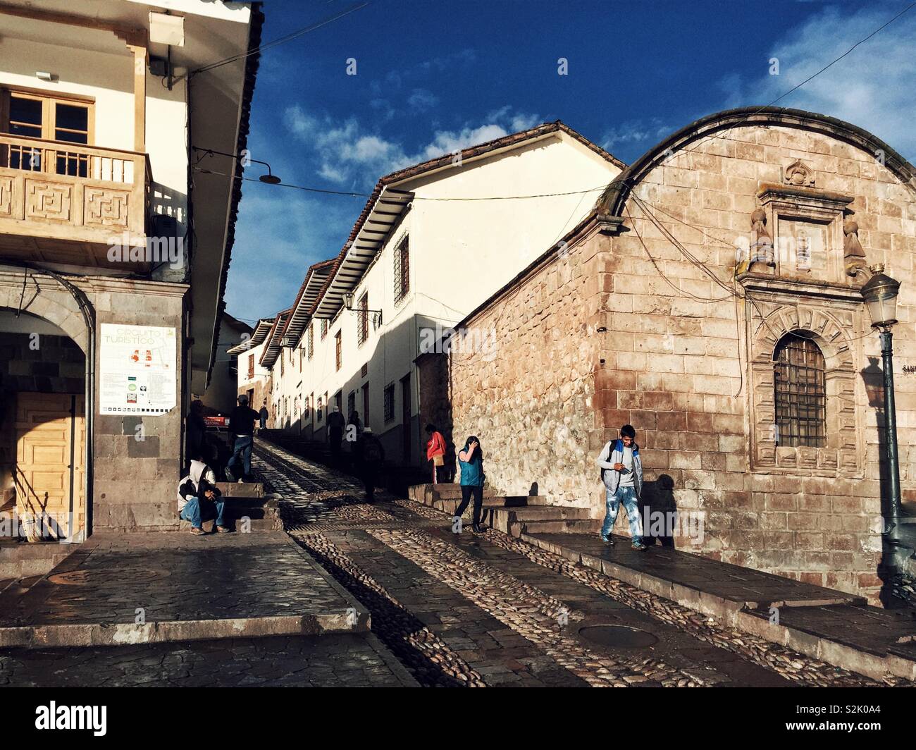 Menschen zu Fuß auf einer steilen Straße in der Altstadt von Cusco, Peru Stockfoto