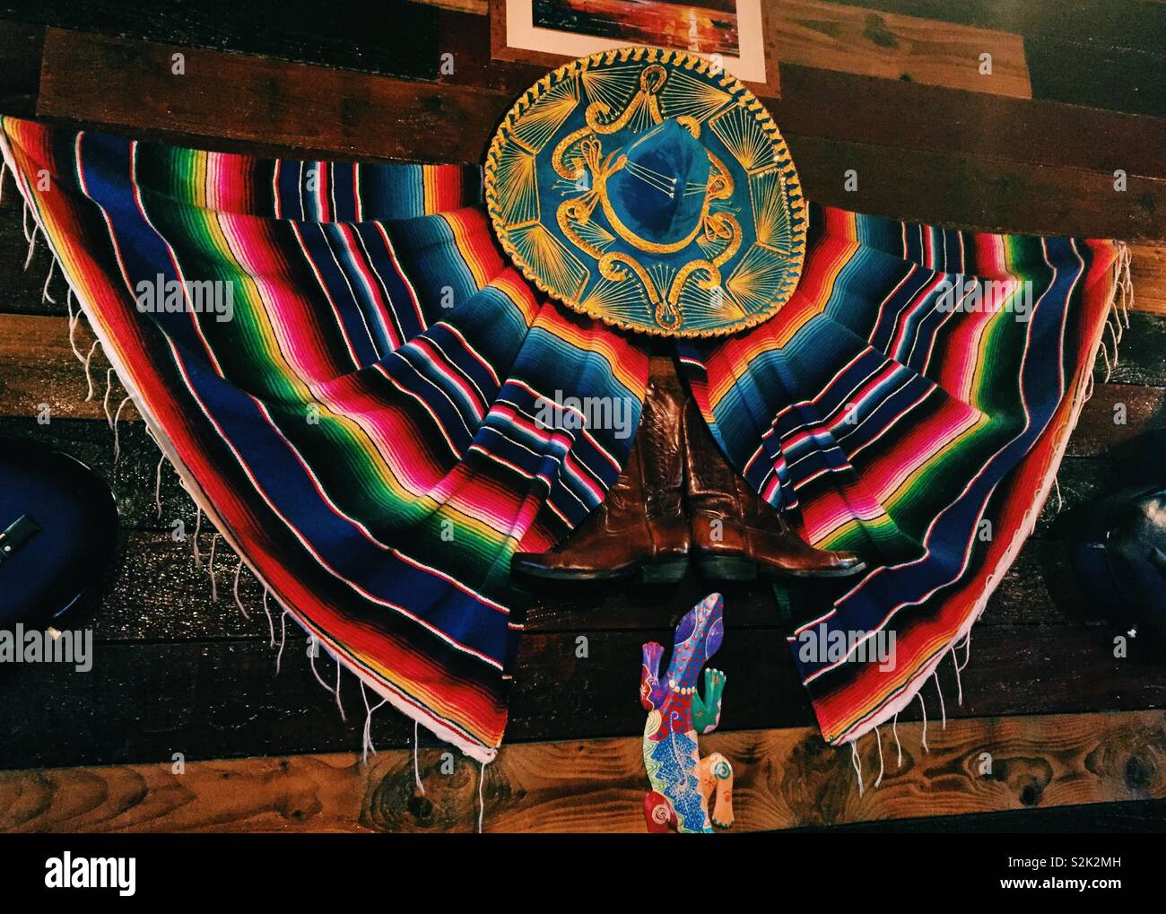 Mexikanischen sombrero Hut und traditionelle bunte Kostüm an der Wand in einem mexikanischen Restaurant - Smartphone-aufgenommenes Stockfoto
