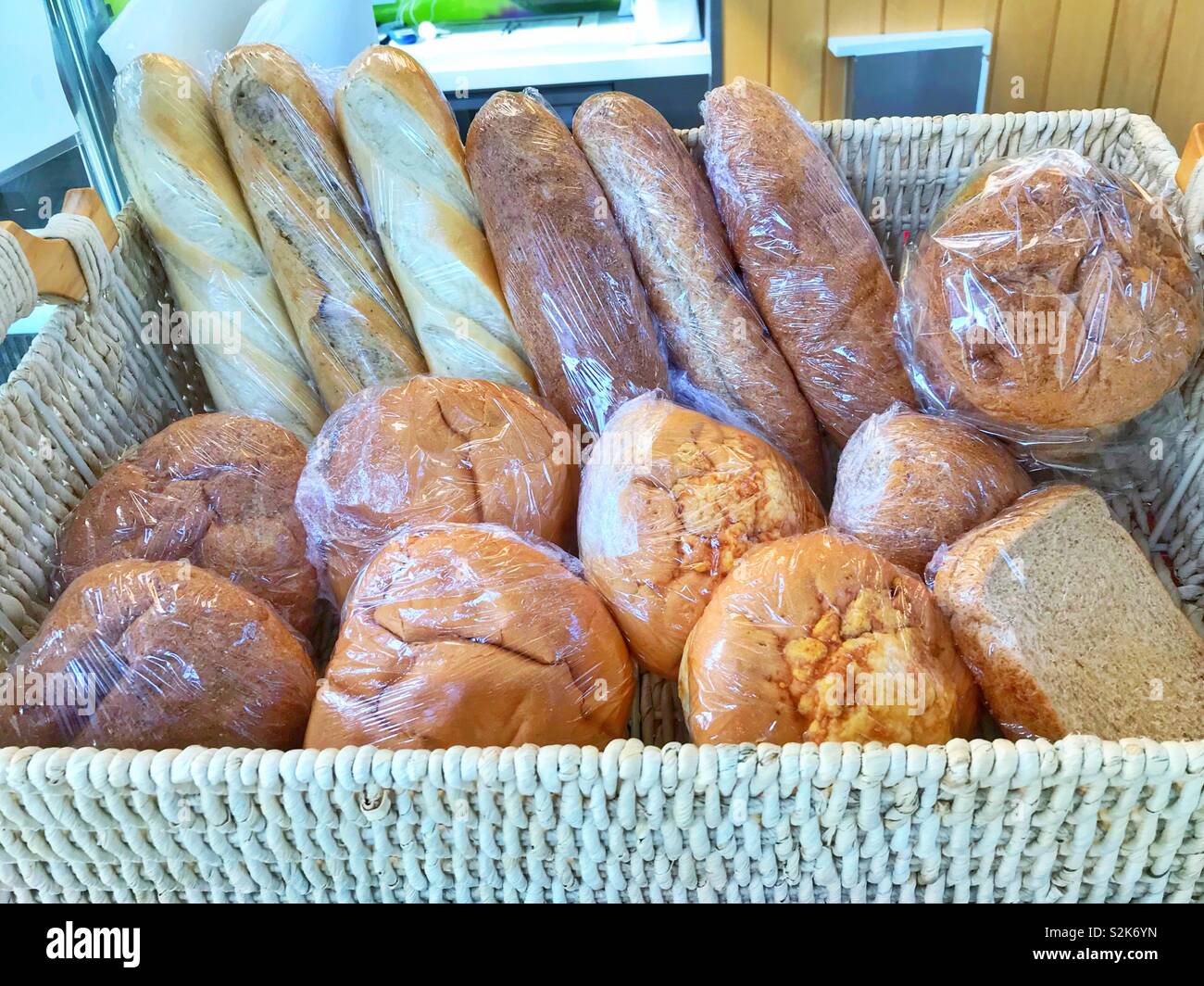 Weidenkorb voll von verschiedenen Arten von Brot - Smartphone-aufgenommenes Stockfoto