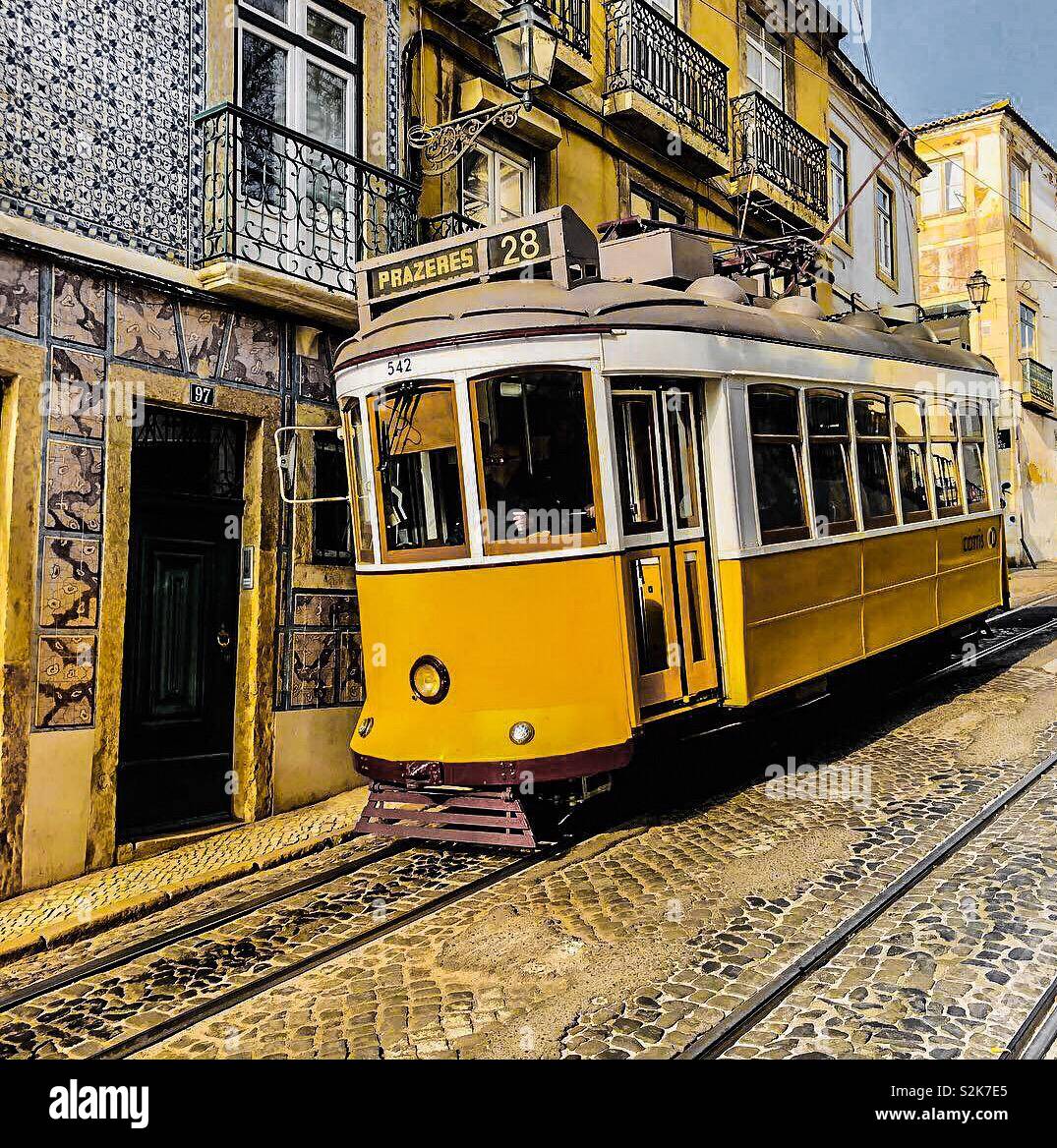 Gelbe tram Bergab fast schabt der Wand Fliesen- Haus in Lissabon, Portugal. Stockfoto