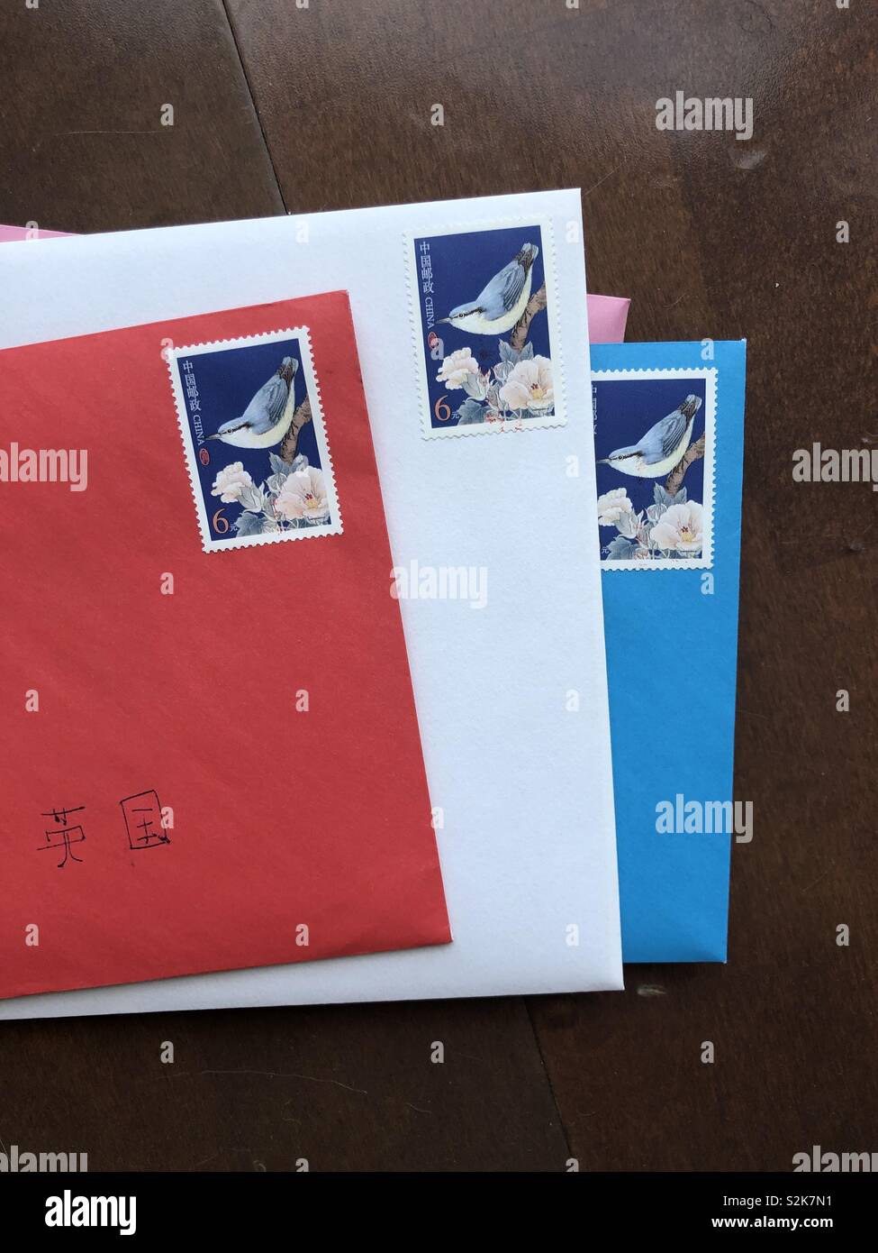 Mehrfarbige Briefe mit Briefmarken in zwangloser Haufen auf einem hölzernen Oberfläche, bereit zu stellen. Stockfoto