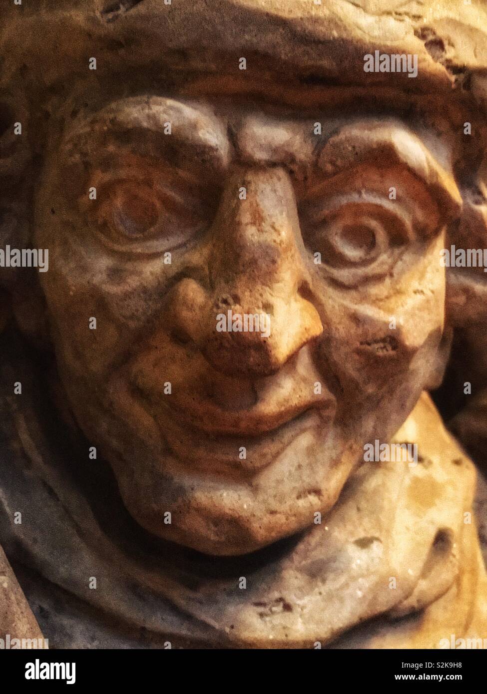 Nahaufnahme von der Statue des Gesicht eines älteren Mannes lächelnd und freundlich. - Smartphone-aufgenommenes Stockfoto