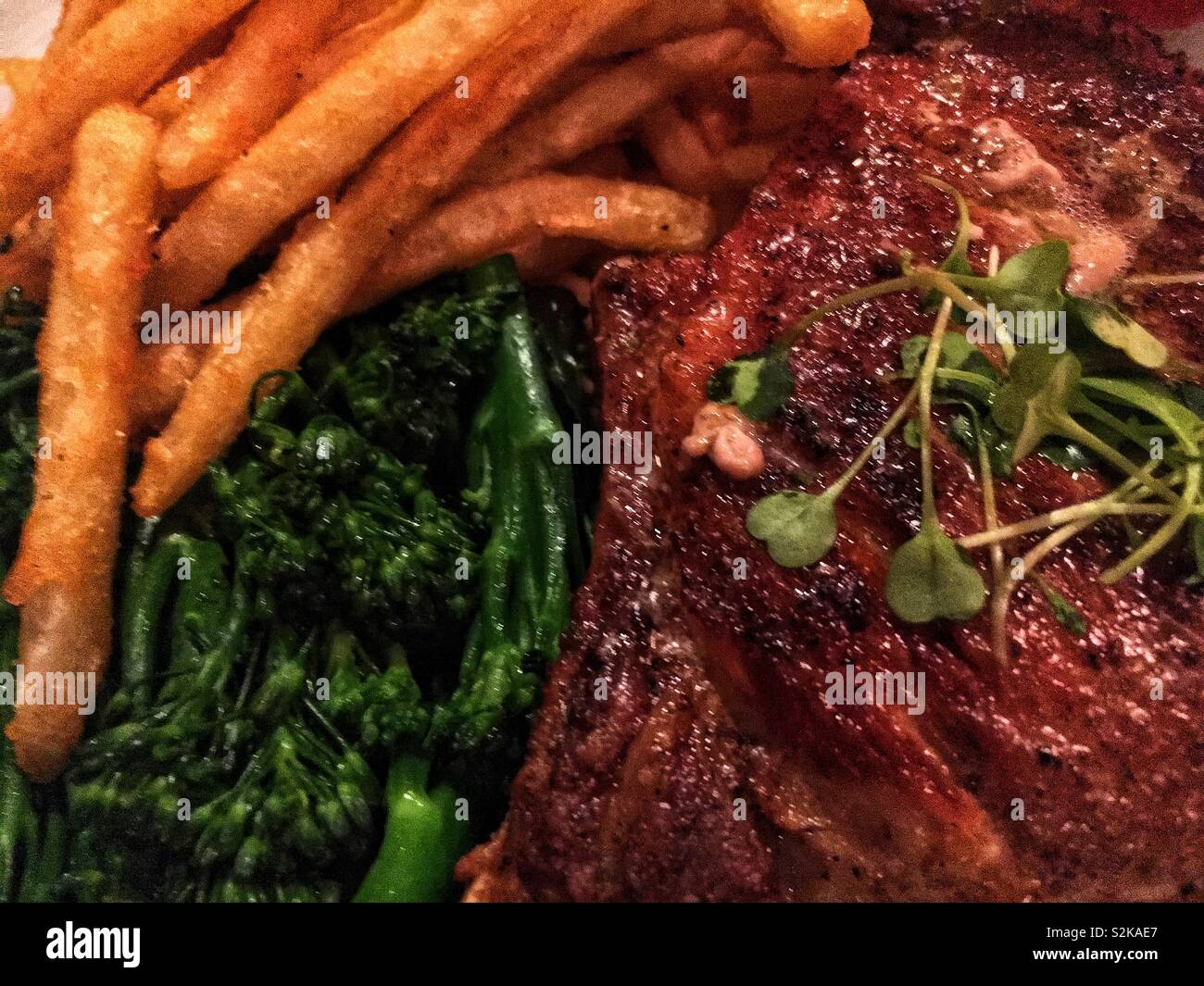 Full Frame Detailansicht der perfekte Steak frites, frischem Brokkoli I, und schmackhaften Schweinekotelett als formale fancy Hauptgericht. Stockfoto