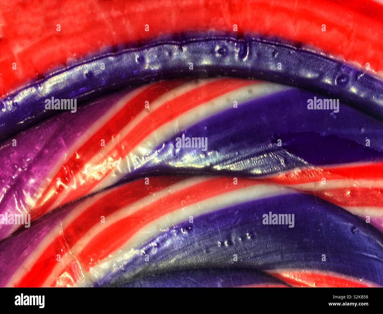 Full Frame eines köstlichen frischen Lila, Blau, Rot und Weiß wirbelte Bonbons Lutscher. Stockfoto