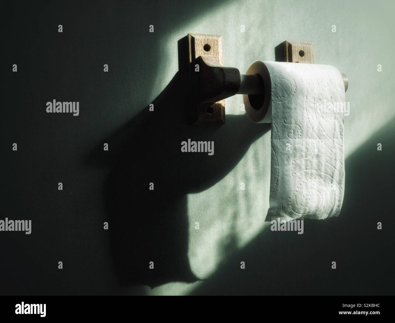 Toilettenpapierrolle auf Holzhalter Stockfoto