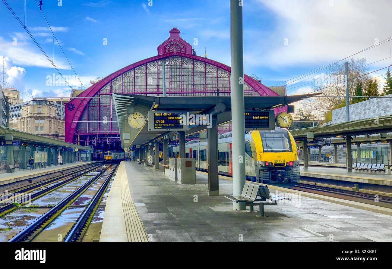 Hauptbahnhof Antwerpen unter einem blauen Himmel nach dem Regen mit einem Zug auf den Schienen neben der Plattform, warten zu lassen - Smartphone-aufgenommenes Stockfoto