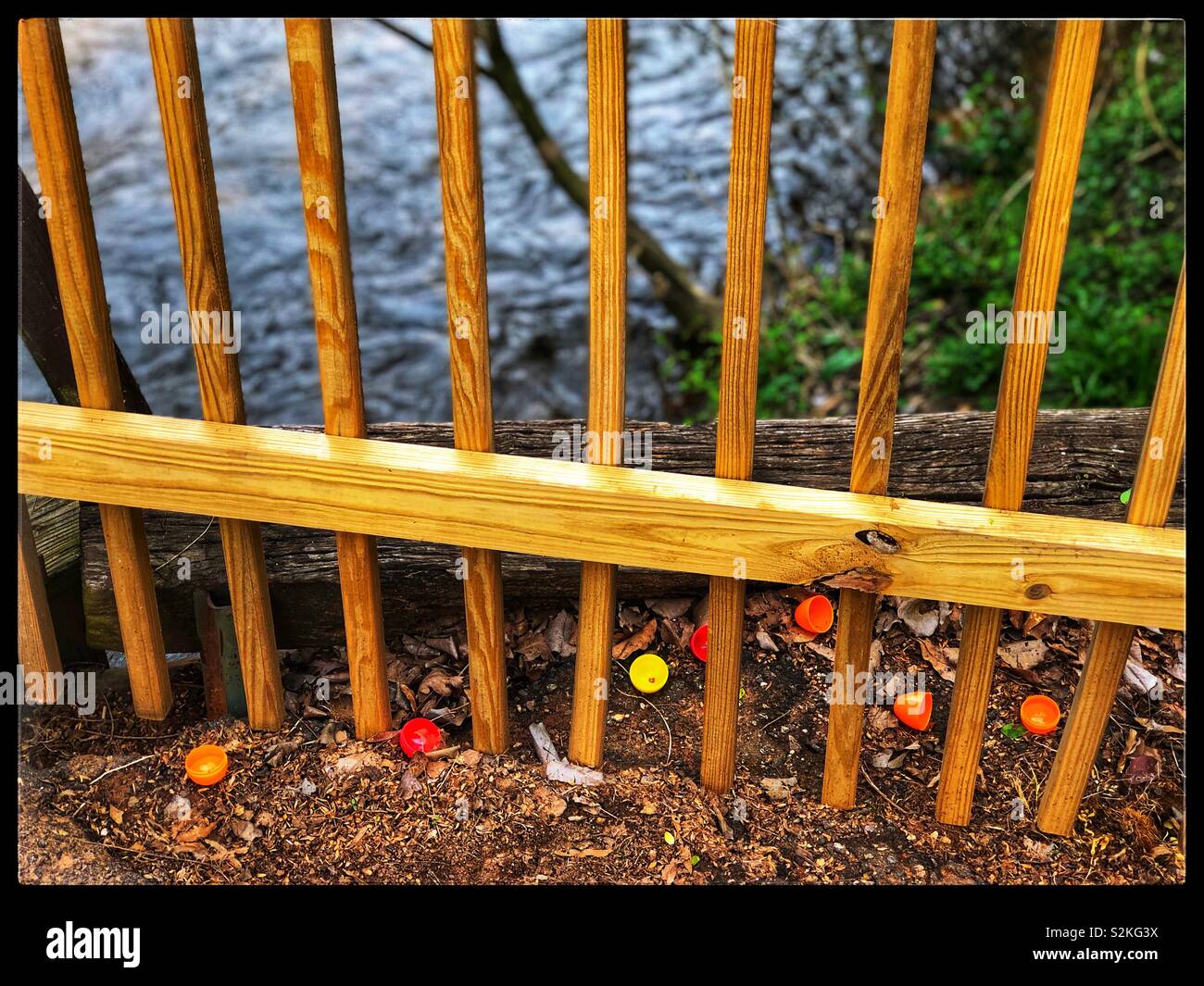 Kunststoff Ostereier zwischen einem Holz Zaun Stockfoto
