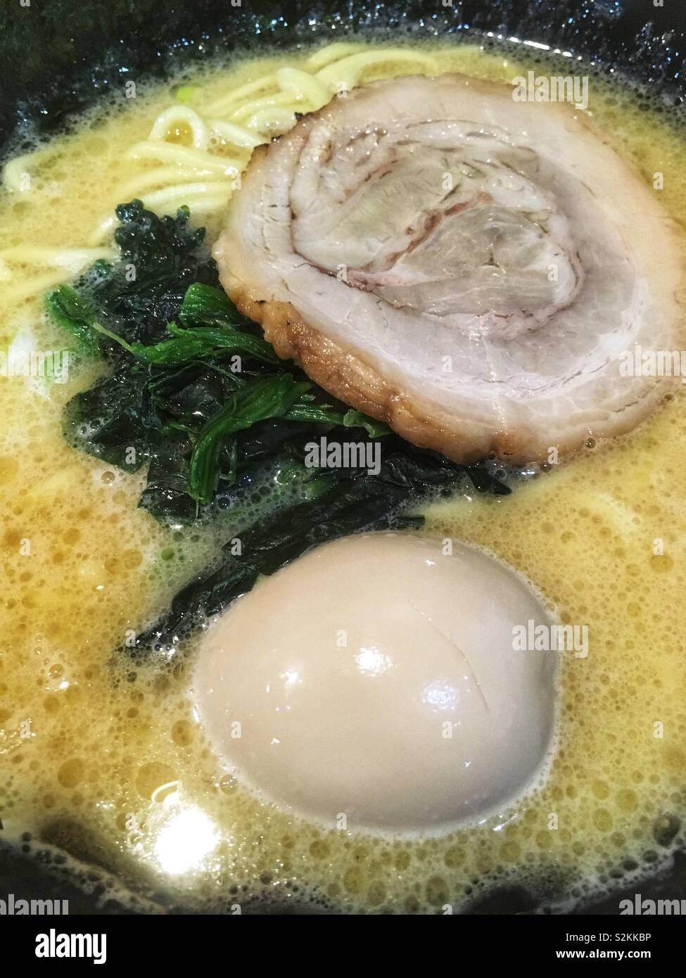 Ramen Nudelsuppe mit Schweinefleisch, Eier und Spinat Stockfoto