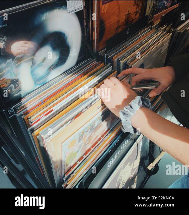 Weibliche Hände surfen Schallplatten in einem Geschäft Stockfoto