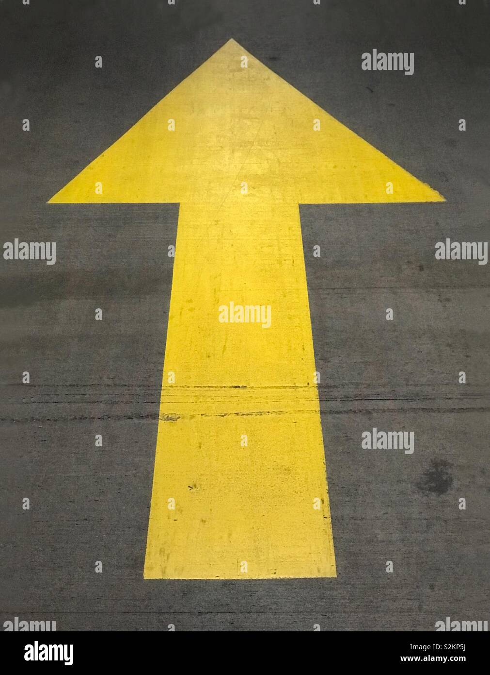 Eine gemalte, gelb, bis der Pfeil auf dem Boden einer Parkgarage gezeigt. Stockfoto