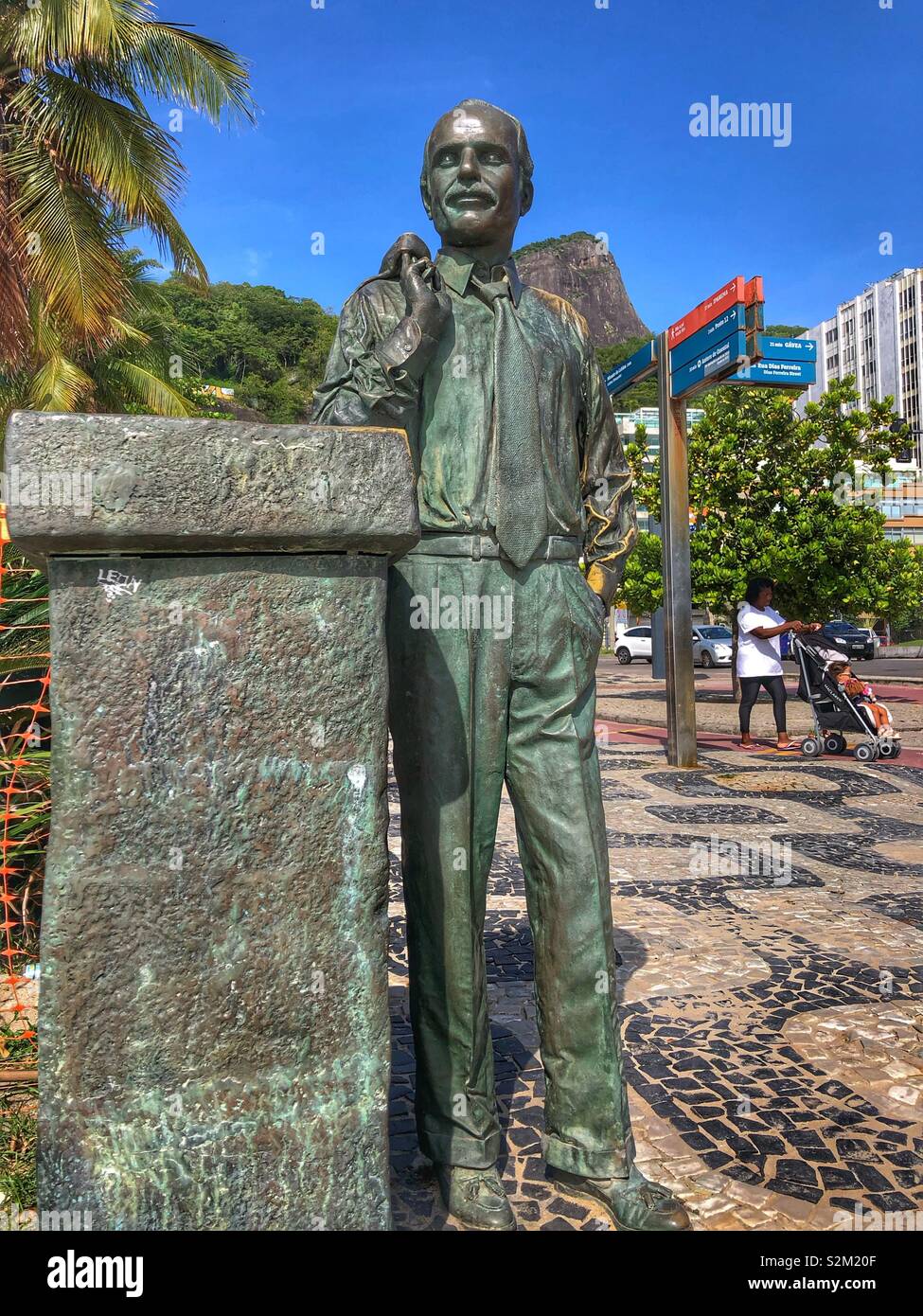 Eine bronzene Statue eines Mannes stehen auf den Strand von LeBlon Promenade in Rio de Janeiro, Brasilien. - Smartphone-aufgenommenes Stockfoto