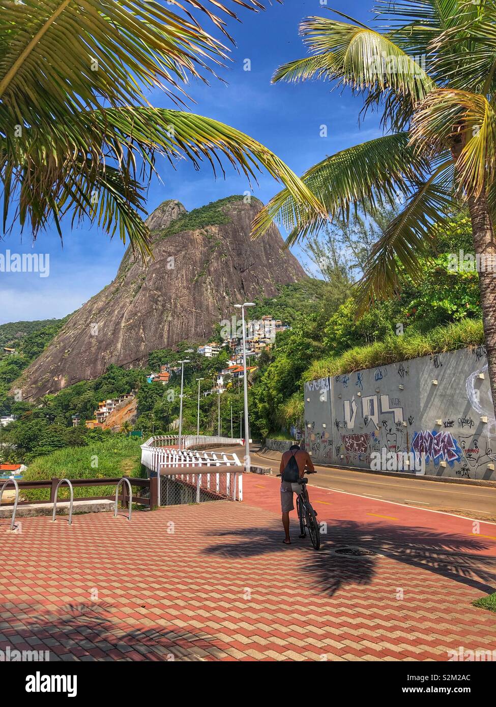 Ein Radfahrer hält für einige Schatten in Rio de Janeiro, Brasilien. - Smartphone-aufgenommenes Stockfoto