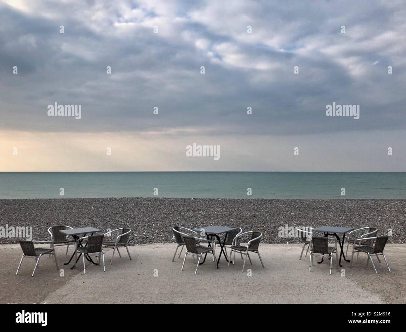 Leere Tische und Stühle am Strand in Dieppe, Frankreich, außerhalb der Saison. Stockfoto