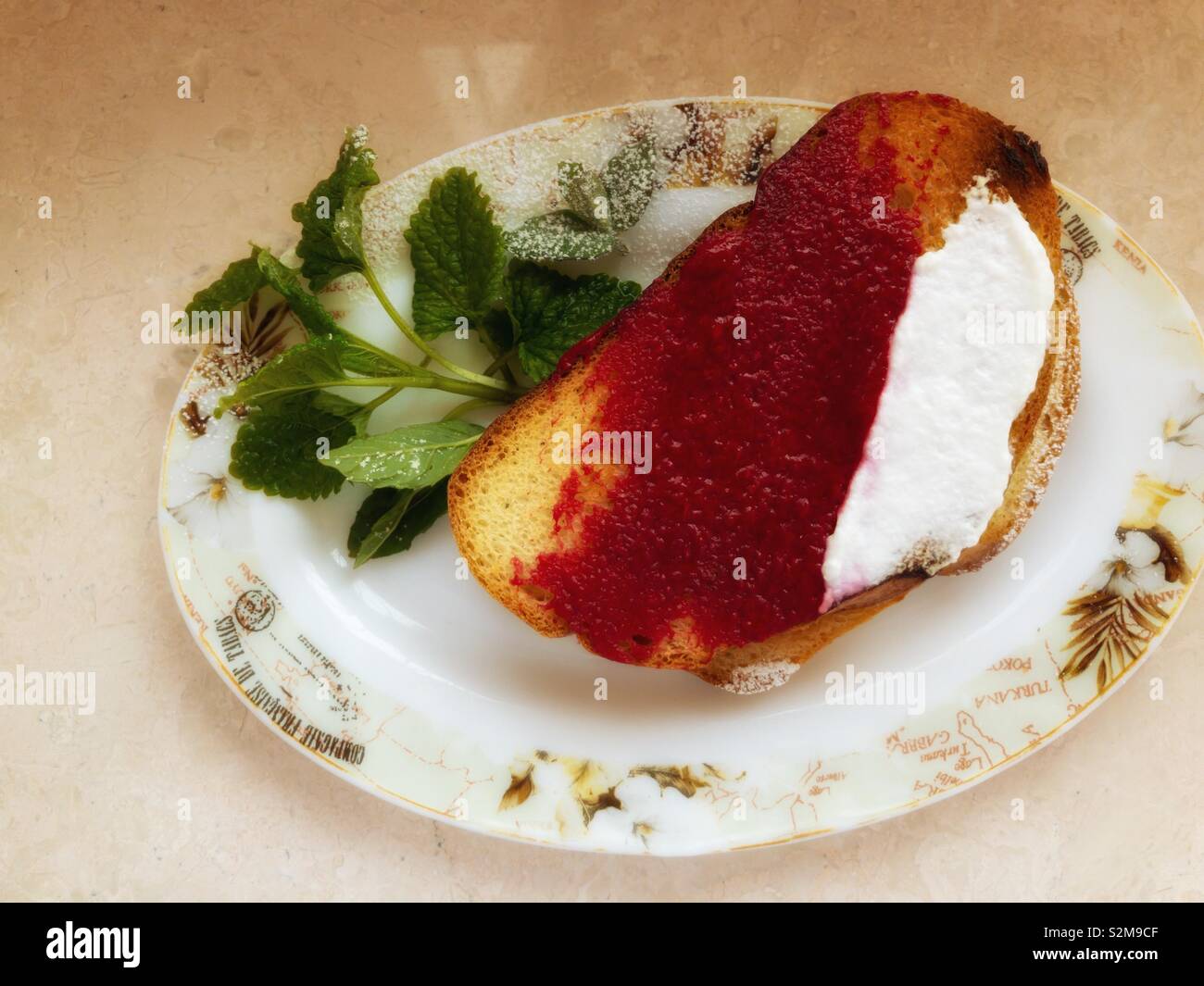 Ansicht von oben auf einem Teller mit Toast mit Himbeere mash und Joghurt abgedeckt Stockfoto