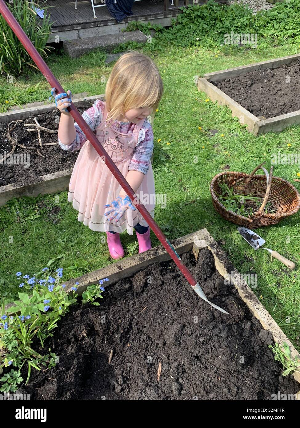 Kleines Mädchen in einem Princess Dress Gartenarbeit Stockfoto