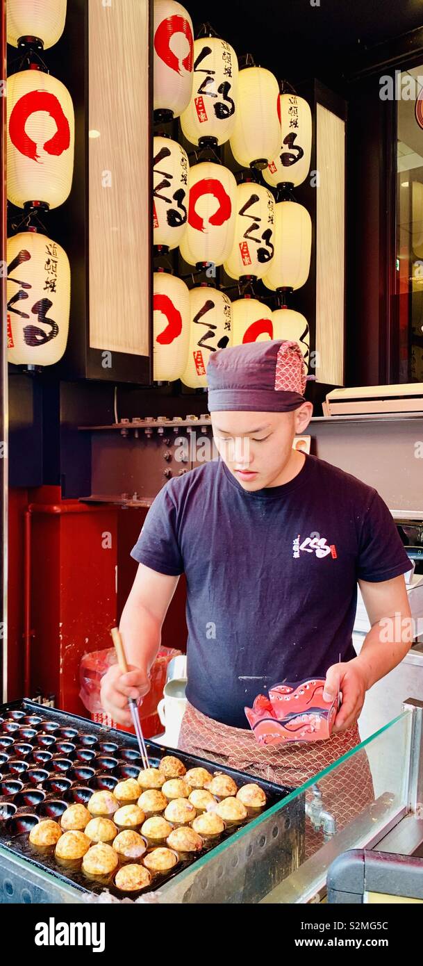 Vorbereitung Takoyaki, Japanisch Octopus Bälle. Takoyaki ist ein beliebter Straße Snack in Japan. - Smartphone-aufgenommenes Stockfoto
