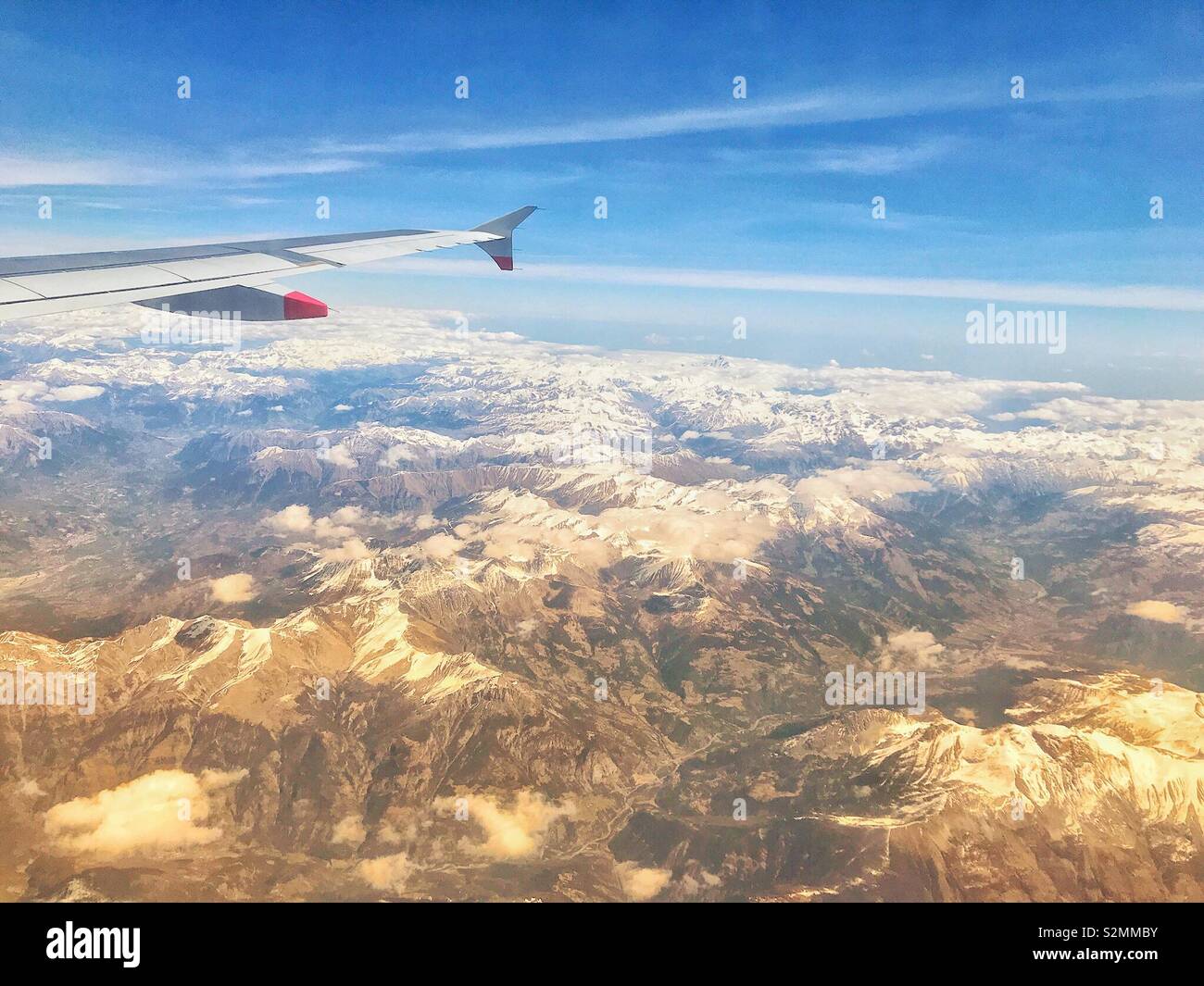 Fliegen über die schneebedeckten Berge im Morgenlicht Stockfoto