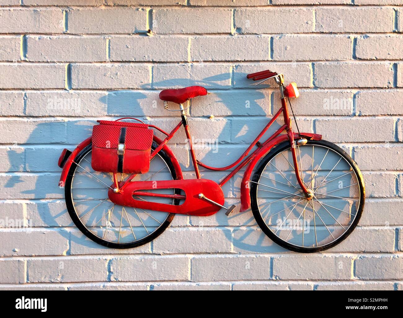 Red Bike auf eine weiße Wand - Dekorative Wand Modell Fahrrad. Stockfoto