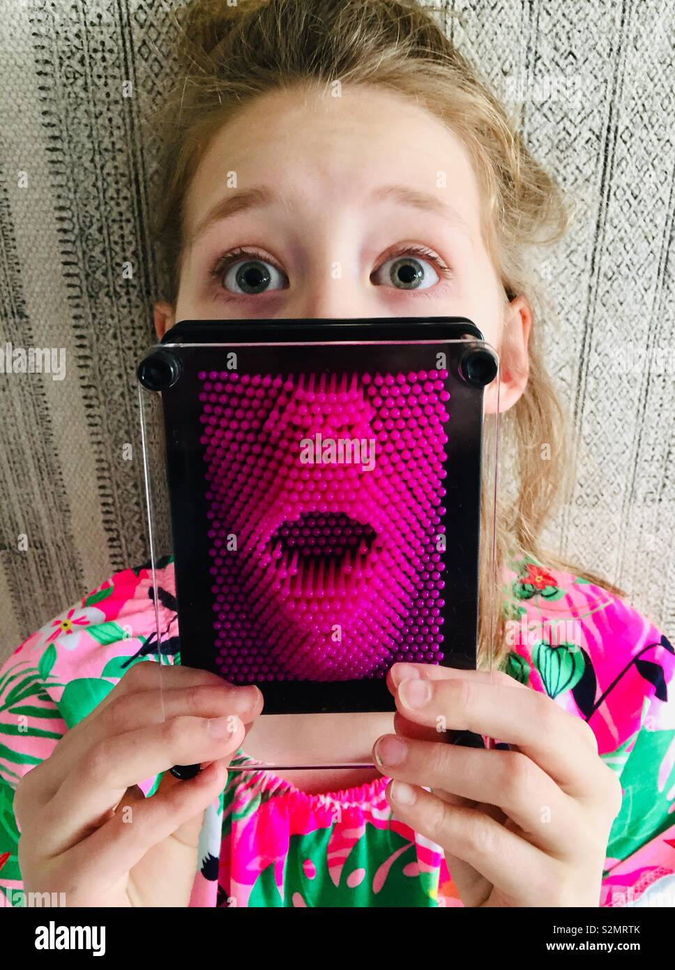 Weibliches Kind mit pinart auf Mund - Smartphone-aufgenommenes Stockfoto