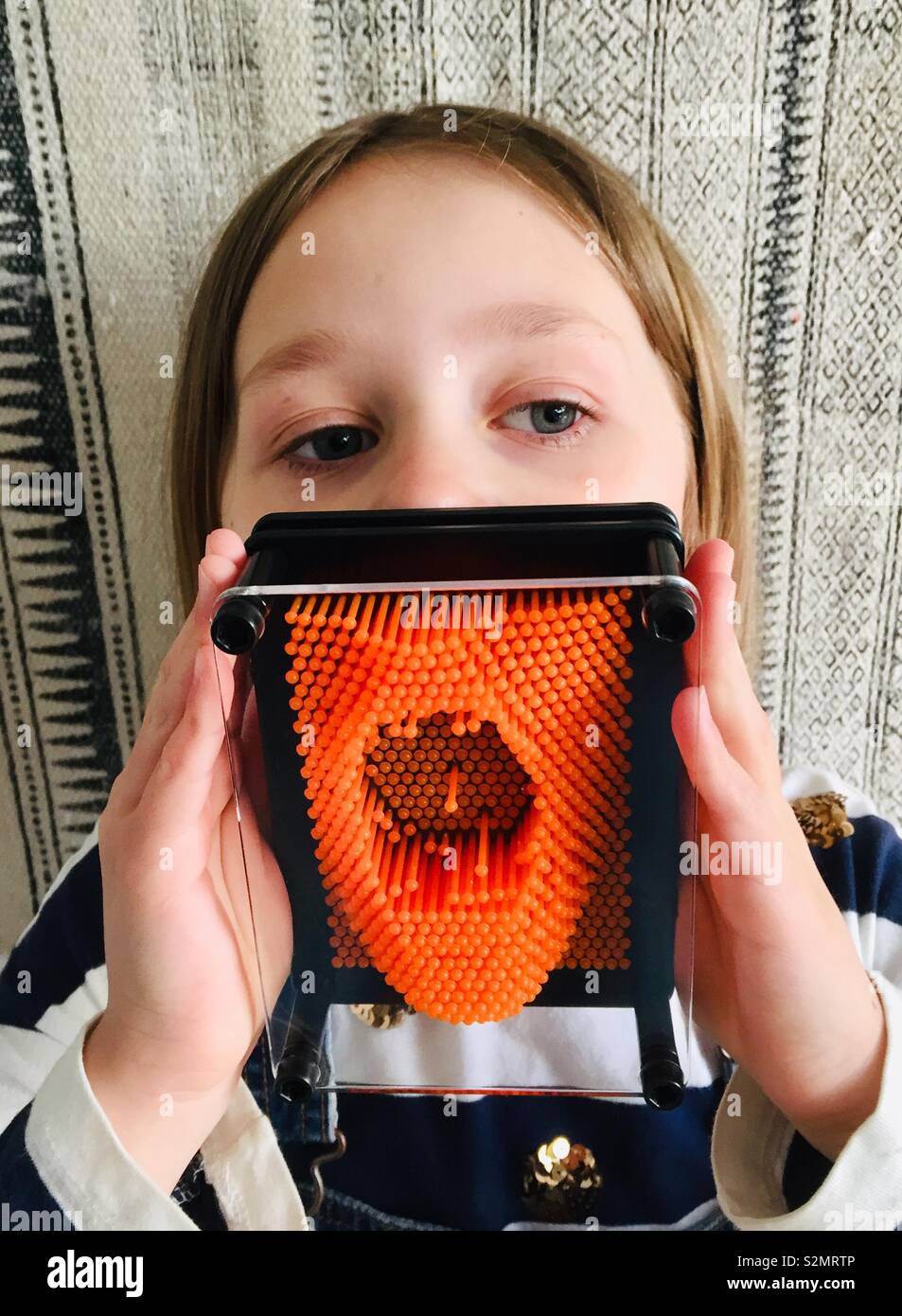 Weibliches Kind mit pinart auf Mund - Smartphone-aufgenommenes Stockfoto
