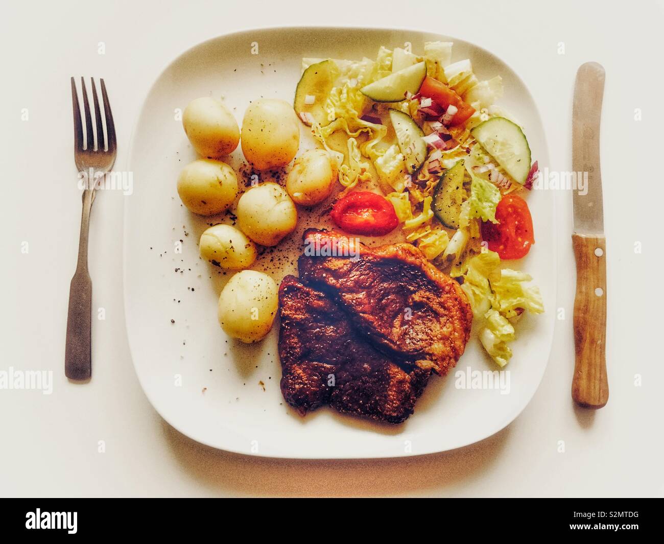 Rindersteak mit neuen Kartoffeln und Salat - Smartphone-aufgenommenes Stockfoto