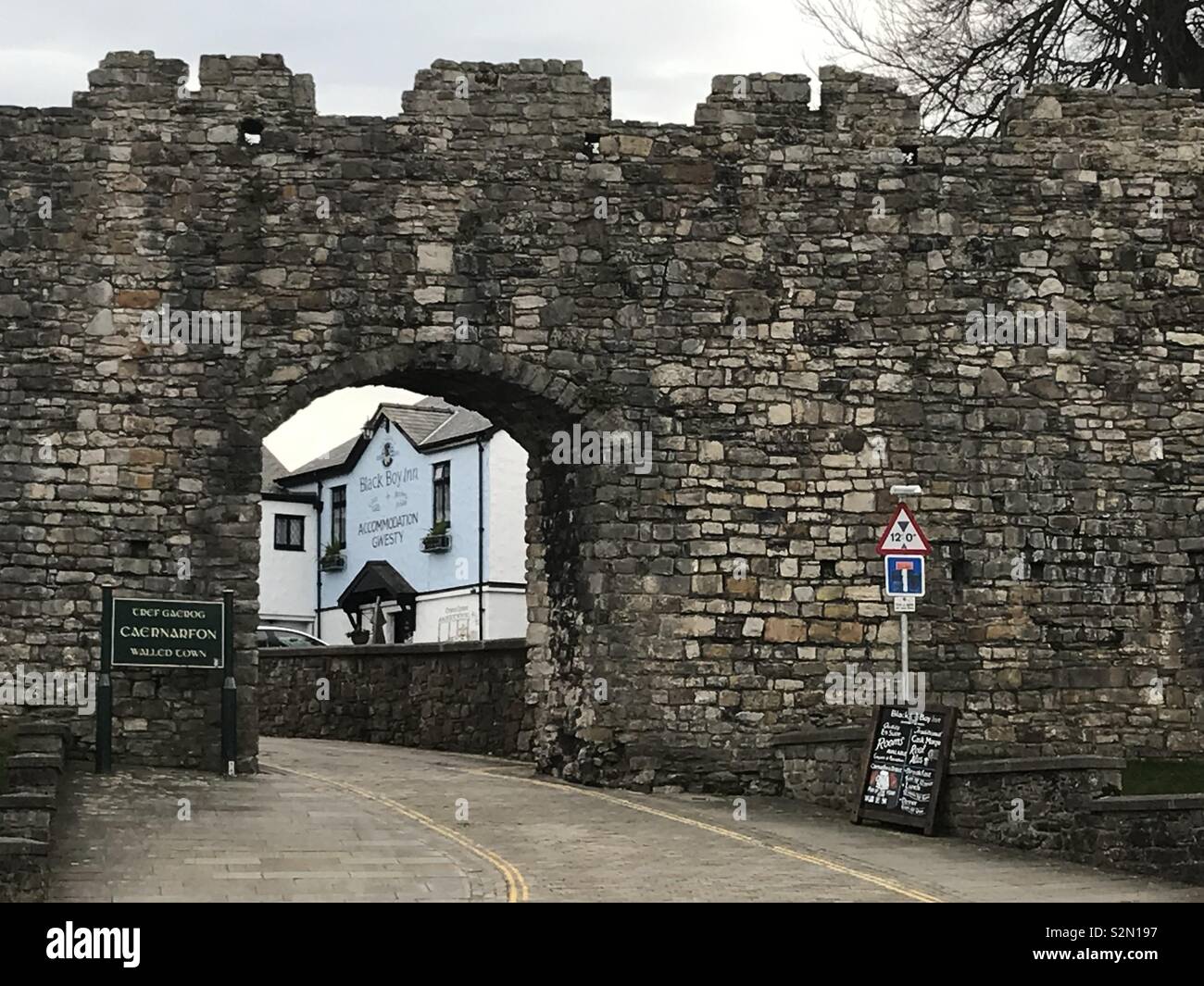 The Black Boy Inn, Caernarfon, durch das Schloss an der Wand gesehen. Stockfoto