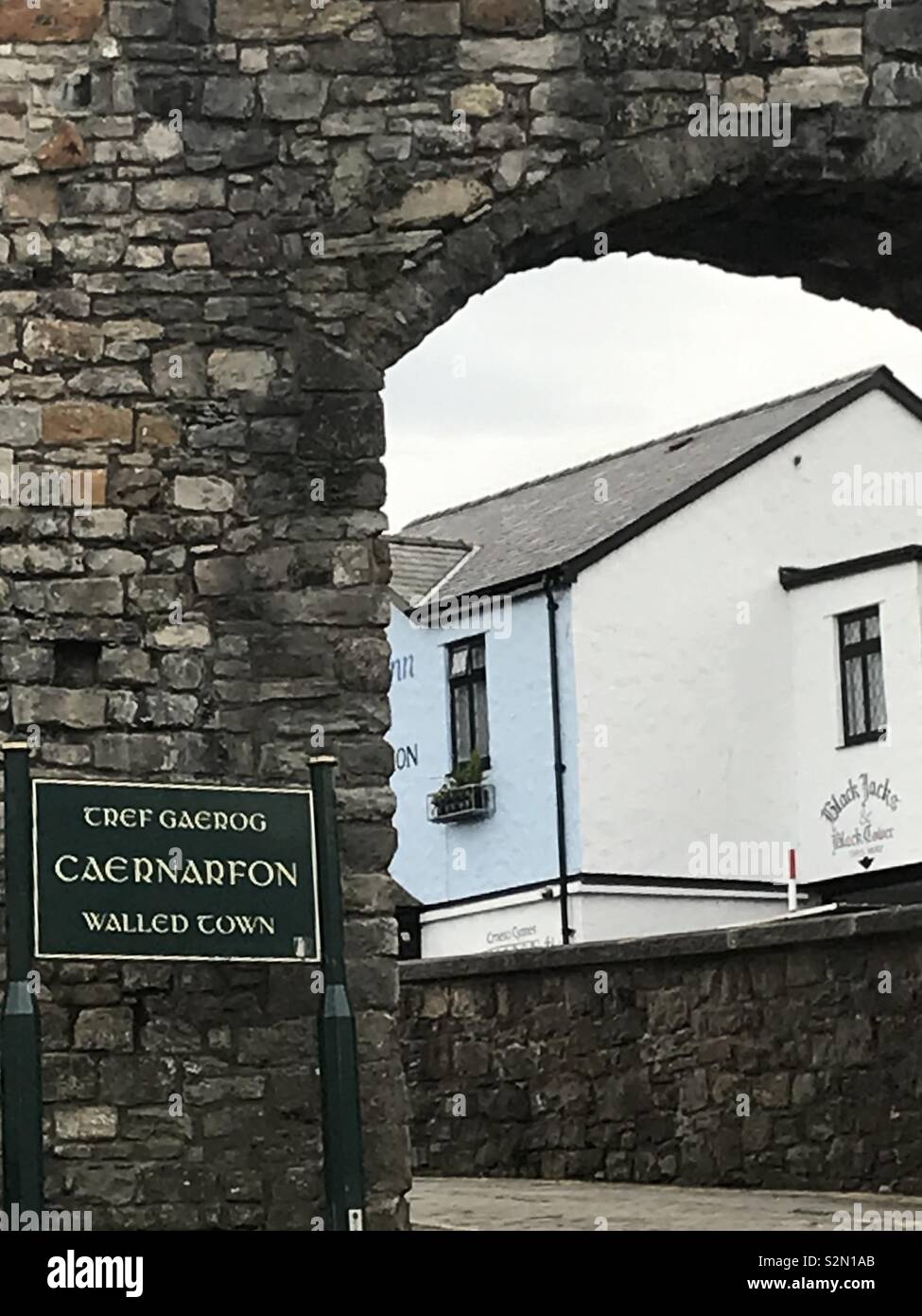 Anzeigen der Black Boy Inn, Caernarfon, Wales, durch das Schloss an der Wand. Stockfoto
