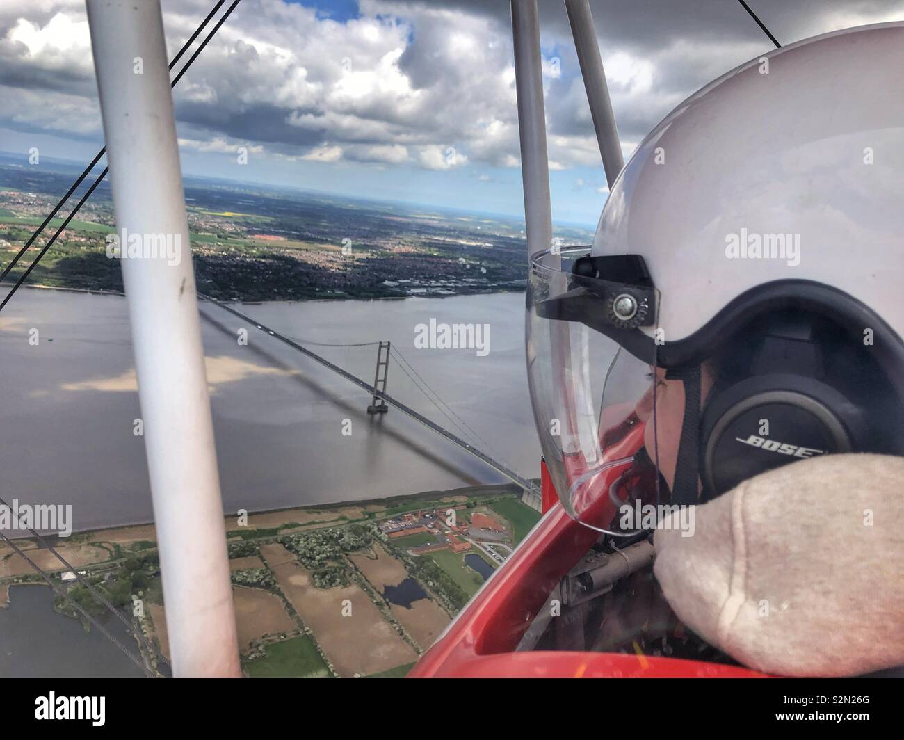 Ein offenes Cockpit Doppeldecker fliegen über die Humber Bridge Stockfoto