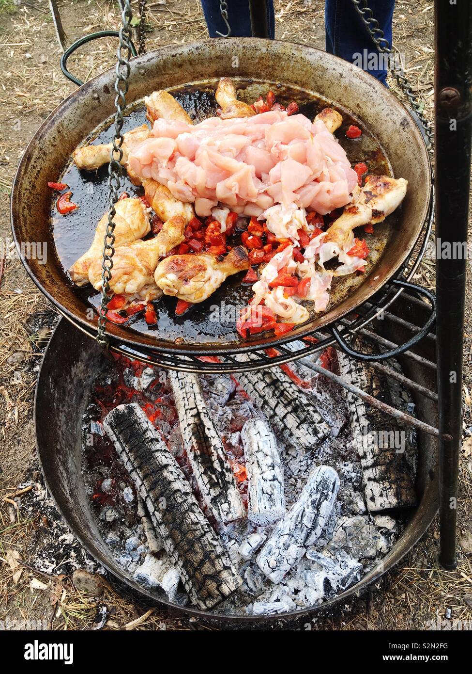 Paella Kochen über offenem Feuer im Freien Stockfoto