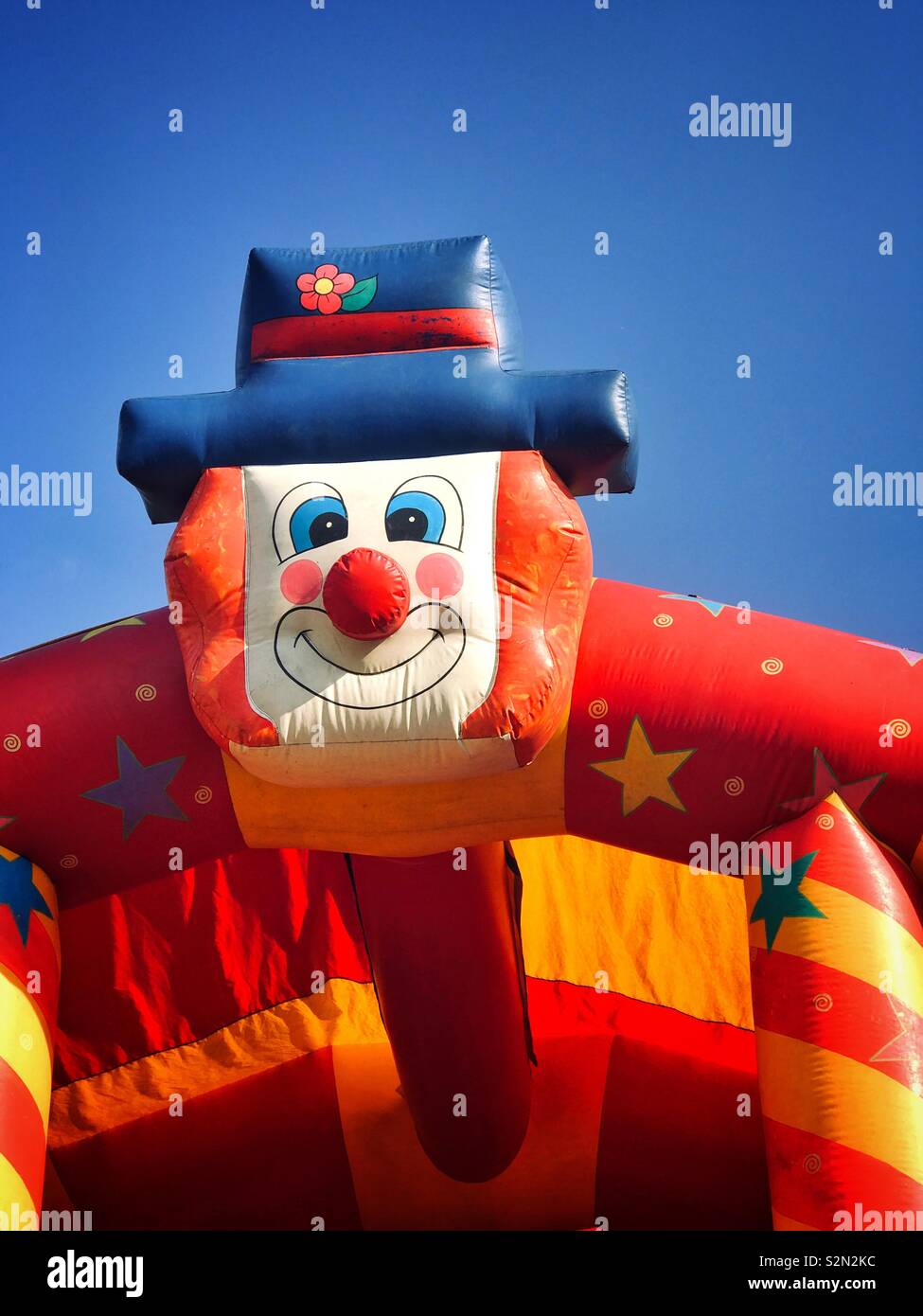 Die große Fläche eines Clown - Teil einer Hüpfburg an einem englischen Sommer Fair (FAYRE). Die Sonne scheint und es ist an der Zeit über und haben Spaß springen! Foto © COLIN HOSKINS. - Smartphone-aufgenommenes Stockfoto
