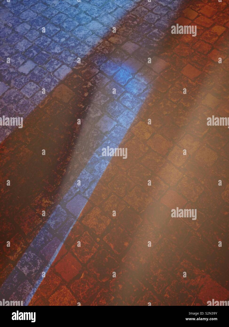 Licht und Schatten spielen über Kopfsteinpflaster. - Smartphone-aufgenommenes Stockfoto