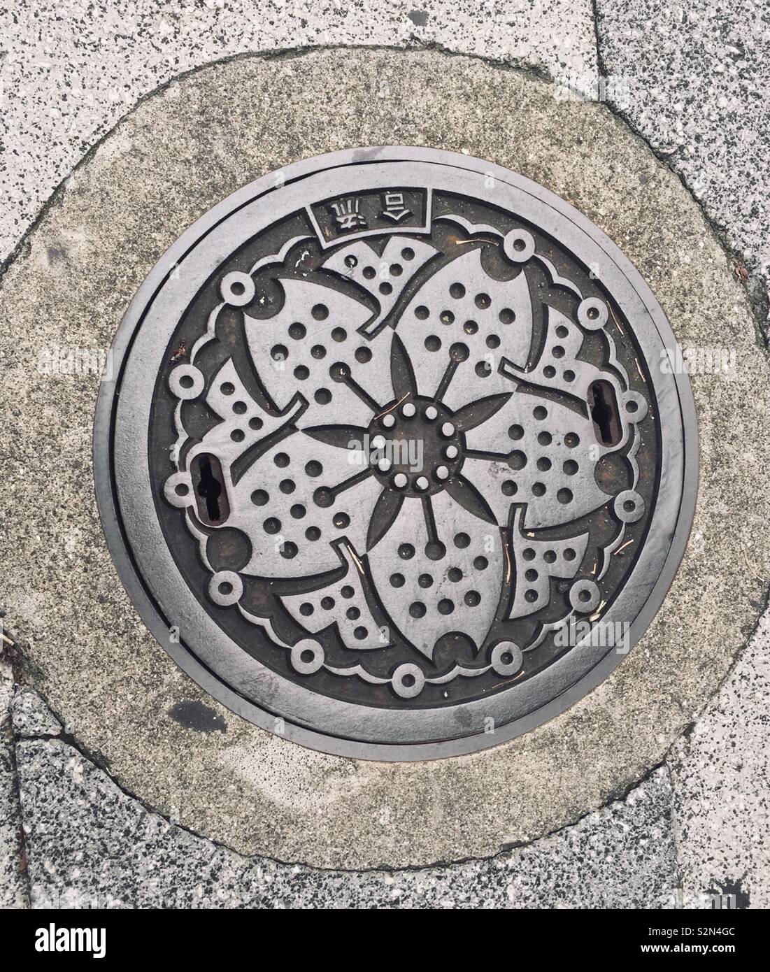 Ein Beispiel für die Haltung der japanischen Kultur hält gegenüber der Natur, der Schönheit und der Kunst ist in diesem einfachen Kanaldeckel Lotus Blossom Muster manifestiert. In Tokio, Japan, sichtbar. August, 2016 Stockfoto
