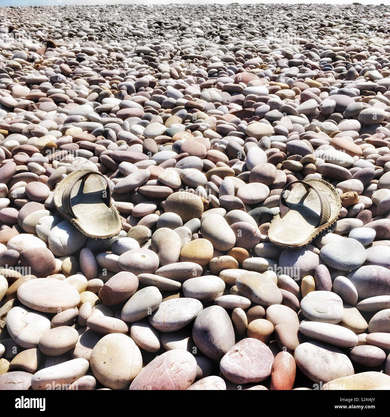 Flip Flops auf Stein Strand Stockfoto